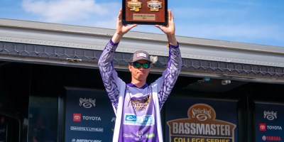man lifts award into the air