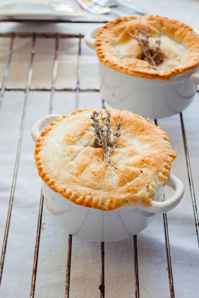 Two individual pot pies made with fall vegetables shown on a rack on a tabletop