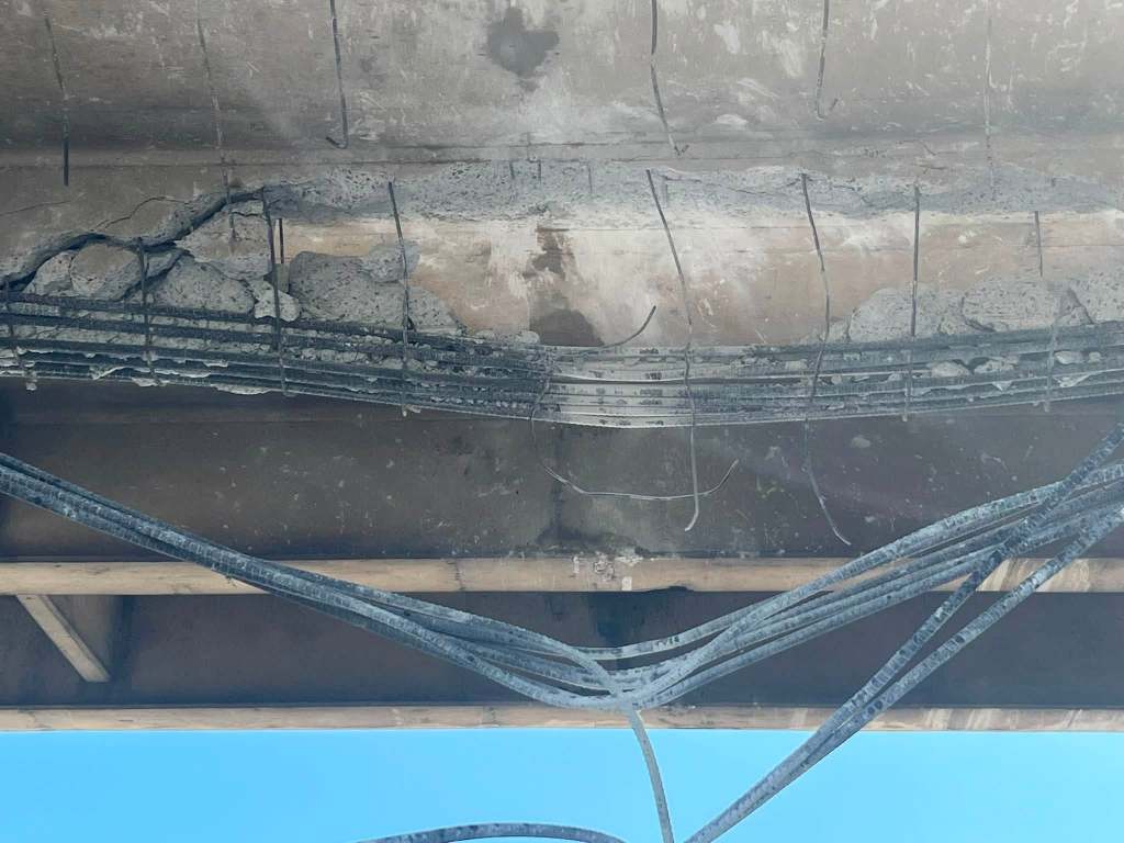 rebar hanging from bottom of concrete bridge