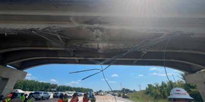 workers looking up at damaged interstate bridge