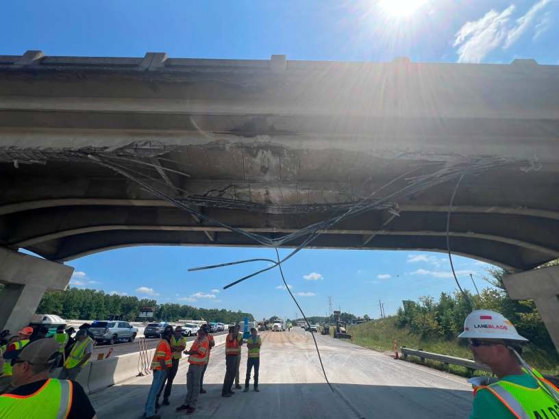 workers looking up at damaged interstate bridge