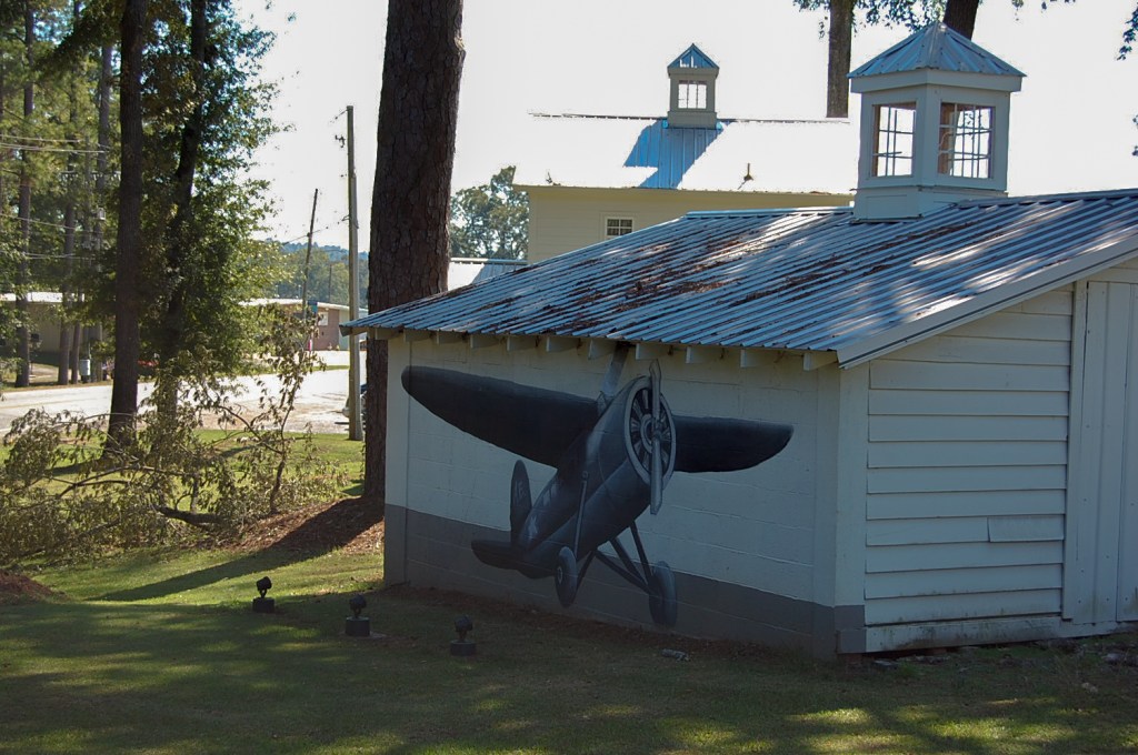 small garage with black and white painting of old aviator plane