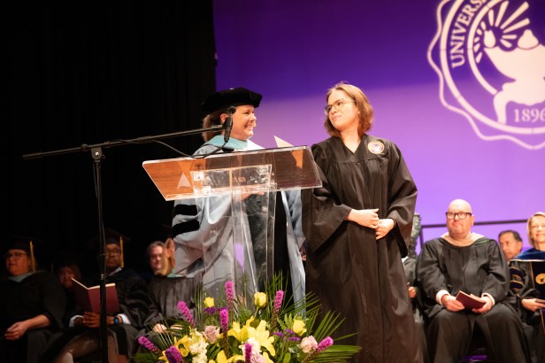 Two women on stage in academic regalia