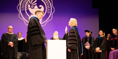 Two people on stage in academic regalia