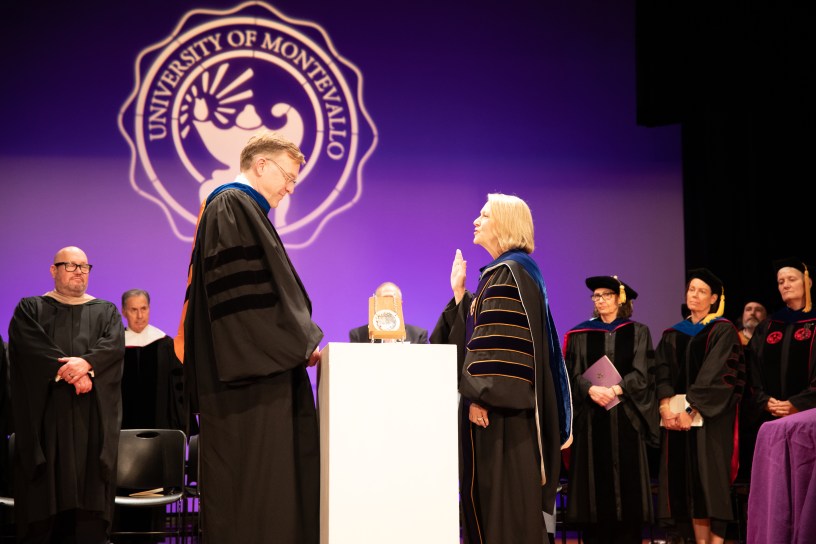 Two people on stage in academic regalia